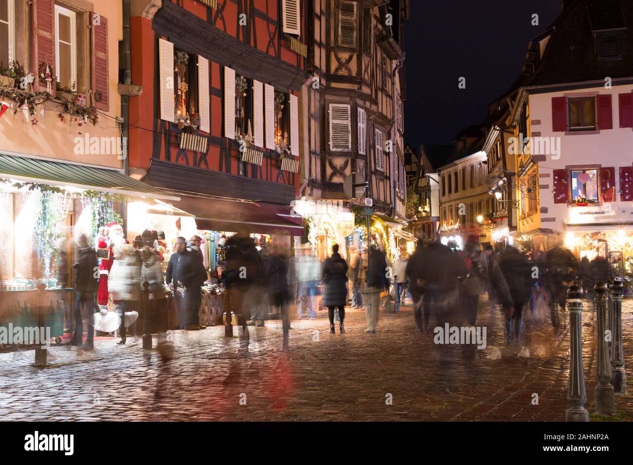 Käufer auf der Straße mit einer langen Verschlusszeit während der Weihnachtsmarkt im Elsass, Frankreich erfasst Stockfoto