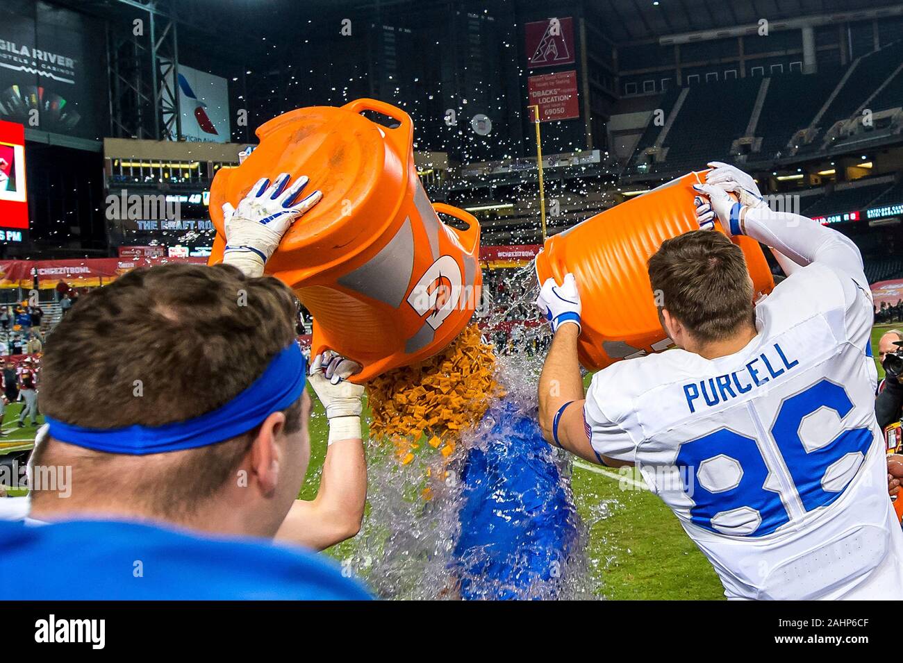 Die US Air Force Academy Football spieler Jared Bair und Michael Purcell armen Cheez-Its und Gatorade über Head Coach Troy Calhoun während der Feiern nach Sieg über Washington State University in der Cheez-It Schüssel Meisterschaftspiel bei Chase Field Dezember 27, 2019 in Phoenix, Arizona. Air Force besiegt Staat Washington 31-21 ihre Saison mit einem 11-2 Rekord und acht Spiel zu beenden Gewinnstreifen ist damit die dritte beste Jahreszeit in der Programmgeschichte. Stockfoto