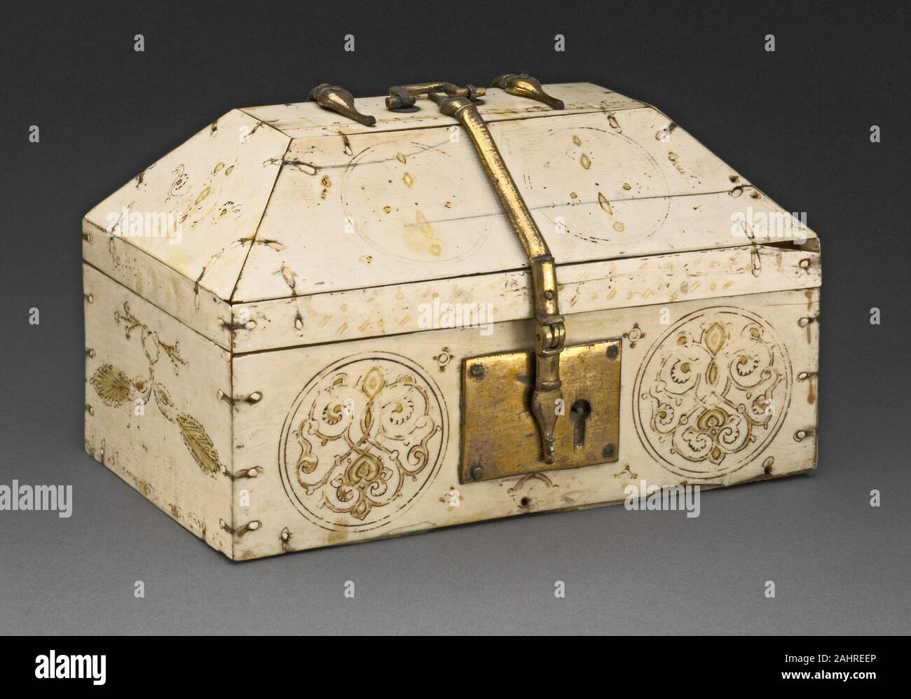 Schatulle. 1100-1199. Sizilien. Elfenbein, Messing, Tempera, und Blattgold Diese Art von kunstvoll bemalten Elfenbein Schatulle in relativ großen Zahlen in Kirche schätze überlebt. Urteilend von ihren arabischen Inschriften, die Wünsche für Glück, Segen oder Herrlichkeit enthalten, ist es wahrscheinlich, dass viele von Ihnen ursprünglich für weltliche Verwendung als Hochzeit Geschenke oder Schmuck Boxen gedacht waren. Sie waren jedoch oft erst später als reliquiare verwendet. Hier Spuren einer Inschrift auf dem vorderen Rand und Deckel lesen, können Herrlichkeit ertragen. Dieses Feld wurde wahrscheinlich auf der Insel Sizilien, ein wichtiger Kreuzungspunkt der Mediterranen tra gemacht Stockfoto