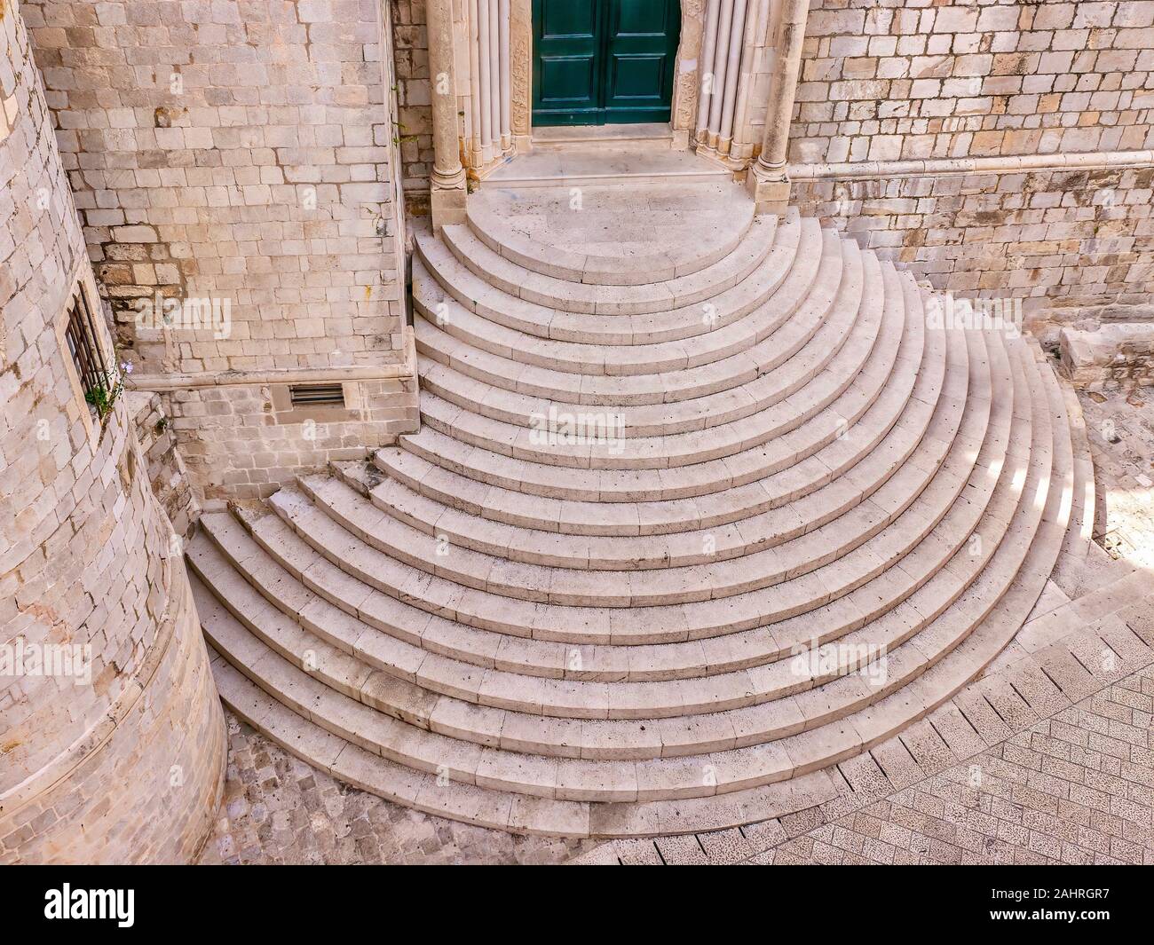 Hohe Betrachtungswinkel der mittelalterlichen halbrunde Treppe aus Stein vor dem Eingang in die Dominikanische Kloster in der Altstadt von Dubrovnik, Kroatien. Stockfoto