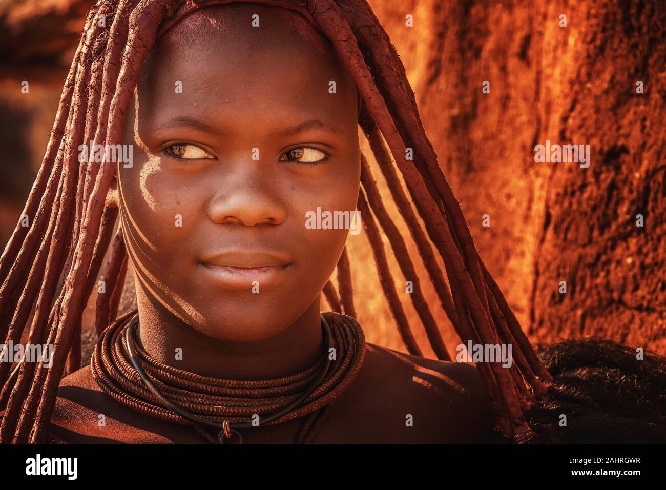 Ländliche Namibia - 22.August 2016. Eine junge afrikanische Frau trägt die traditionelle Frisur, Lederbänder, und Ocker - getönte Haut Einfügen der Himba Stamm Stockfoto