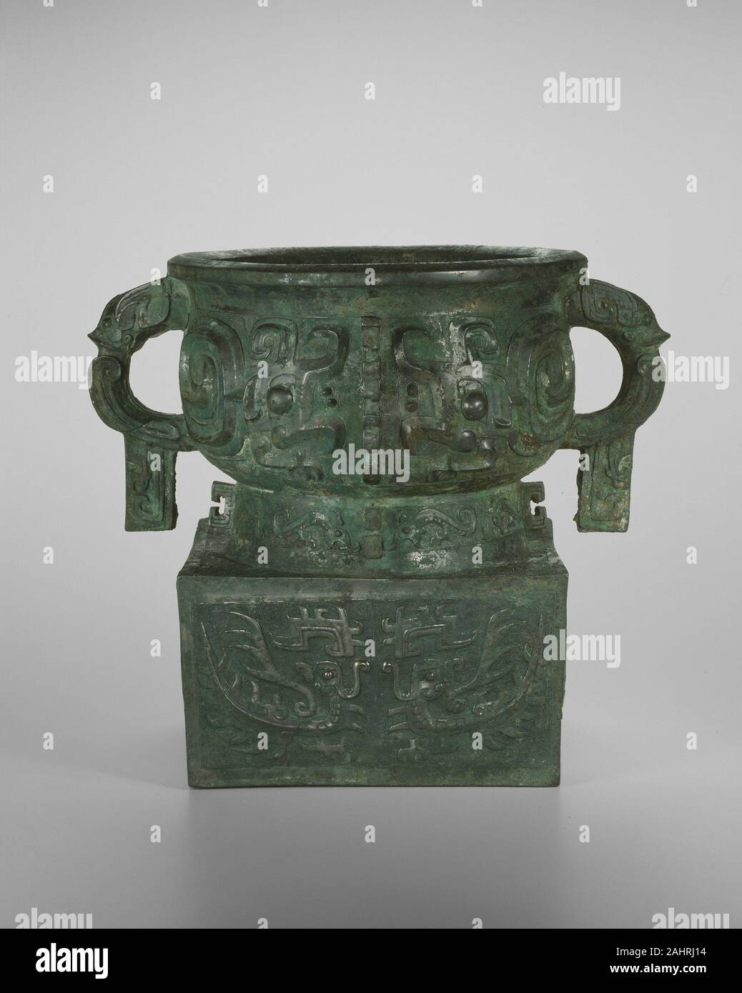 Essen container. 1050 v. Chr. - 1000 v. Chr.. China. Bronze Die umgeschlagenen Terrine ist eins einer umfangreichen Reihe von Bronze Schiffe von Royal China's Familie und politischen Aristokratie für die Erstellung und das Angebot von Hirse und andere Lebensmittel in den zeremoniellen Bankette in Auftrag gegeben. Dieses Schiffes unverwechselbaren Stil, mit seinen Becken cast auf einem hohlen quadratischen Grundfläche von einem Altar oder abgeleitet wurden, wurde bald nach der Zhou Eroberung Chinas erste archäologisch verifiziert Dynastie, die Shang eingeführt. Überschwänglich phantasievolle Kreaturen Animieren der Oberfläche. Zwei große, gewundenen Drachen auf jeder Seite der Schüssel verteilen; Tier Stockfoto