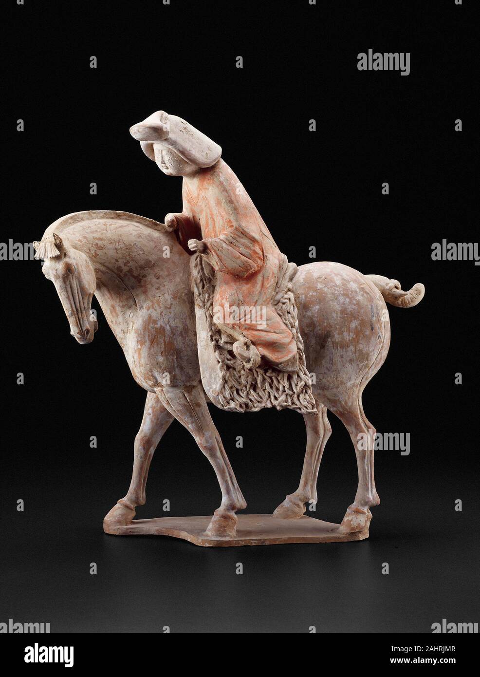 Equestrienne. 725 AD - 750 AD. China. Steingut mit mehrfarbigem Pigmente Chinesischen keramische Figuren ausschließlich für die Beerdigung, oft sehr anschaulich die Moden und Freizeitaktivitäten Ihrer adeligen Besitzer evozieren. Diese Abbildung sensibel fängt einen ruhigen Moment im Leben eines matronly equestrienne, der sanft führt ihr Pferd. Kräftiger Hals des Tieres und Flanken, lange Beine, getrimmt Mähne, und dekorativ Schwanz gebunden sind, verfügt über eine Besonderheit der stattlichen Rassen, die von der nordwestlichen Grenzen des Imperiums zu China sowie von Websites gebracht wurden als weit nach Westen als der Aralsee. Vorsichtig Stockfoto