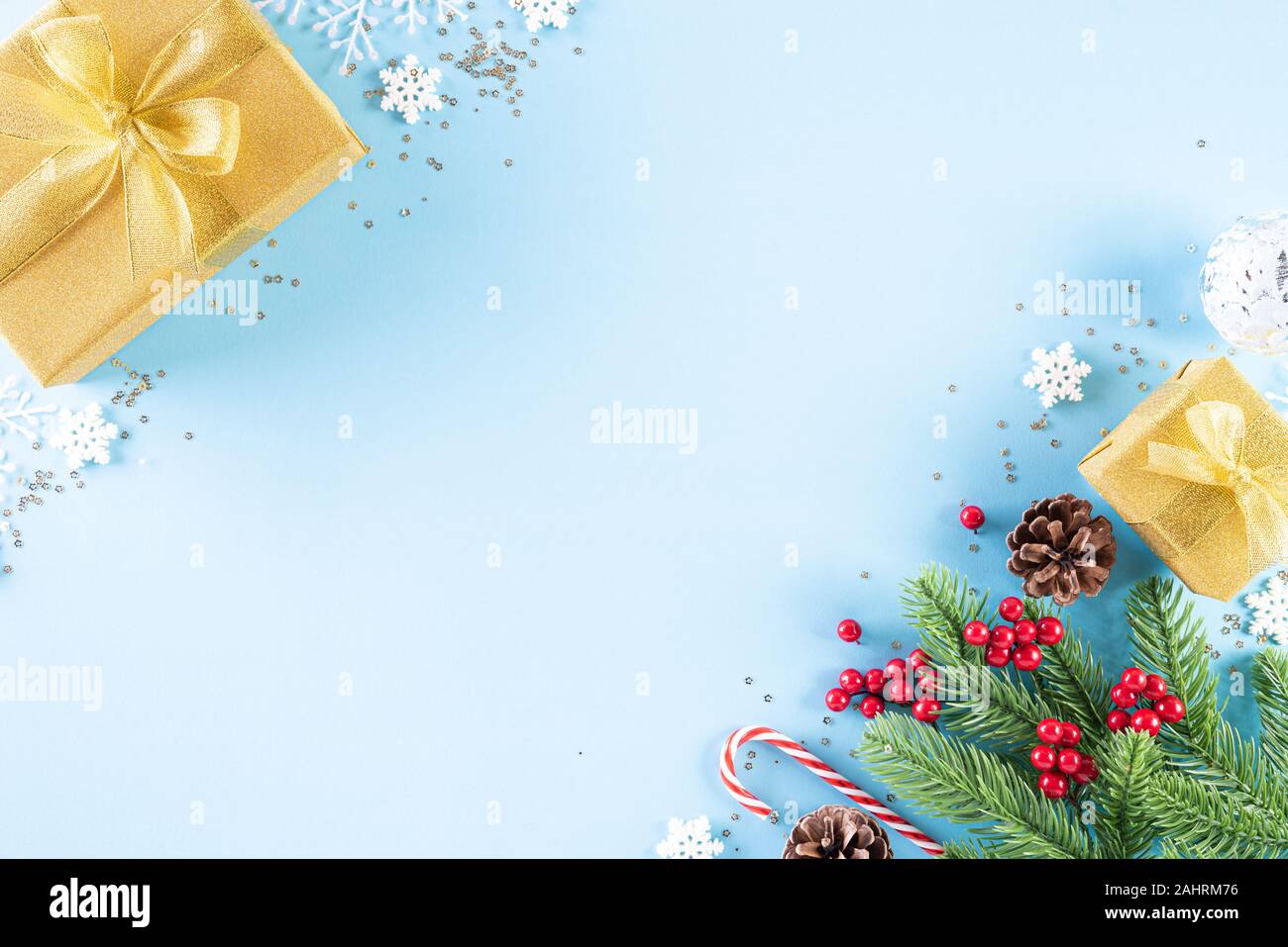 Weihnachten Hintergrund Konzept. Blick von oben auf die Weihnachten goldenen Geschenkkarton mit Zuckerstange Dekoration, fichte Äste, Stern, roten Beeren und Glocke auf leichte b Stockfoto