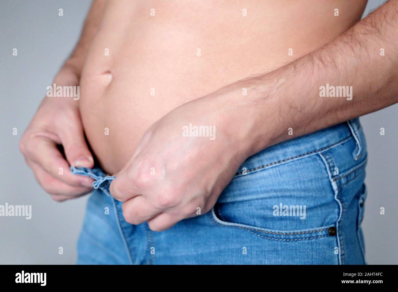 Übergewicht und Adipositas, Fat Belly, Mann in Aufgeknöpfte Jeans. Gewicht Verlust Konzept, abnehmen und Diät, Gesundheit Stockfoto