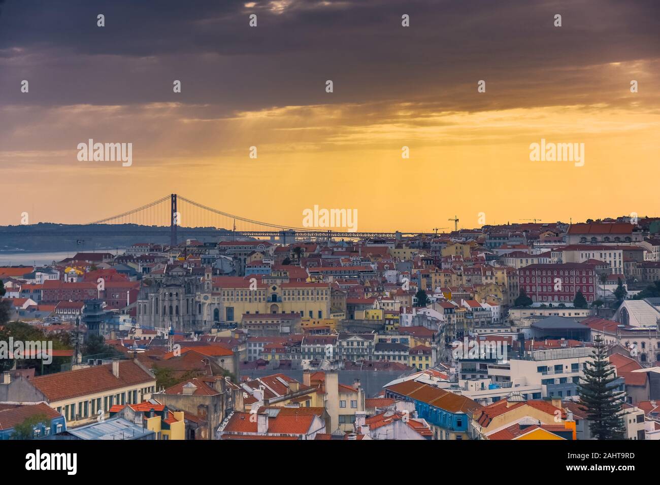 Lissabon Panoramablick. Bunte Wände der Gebäude von Lissabon, mit orangefarbenen Dächern und der 25. April Bridge im Hintergrund, bei Sonnenuntergang. Reisen Stockfoto