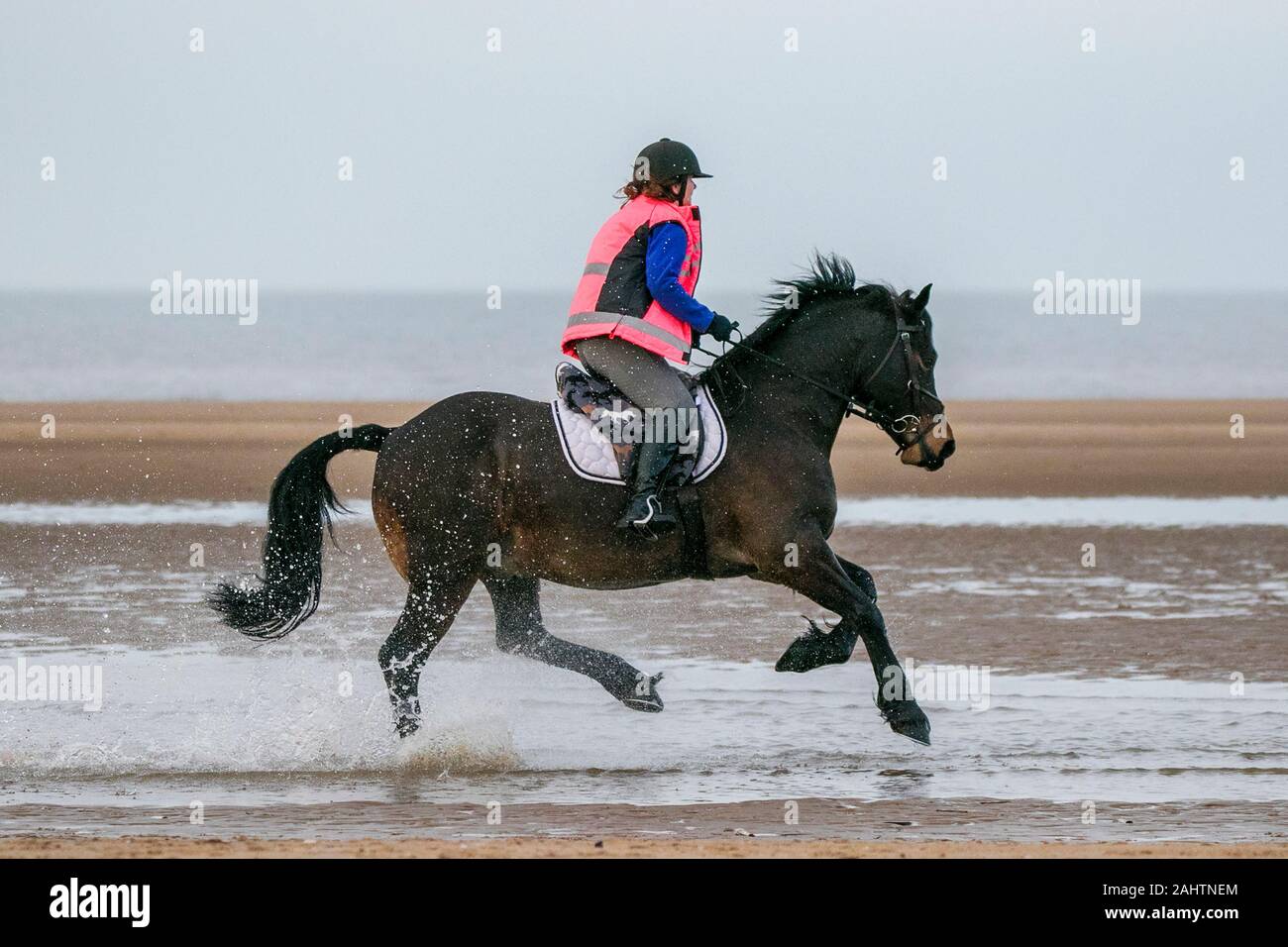 Southport, Merseyside, 1. Januar 2020. Reiter ihre Pferde für einen neuen Jahren Tag Galopp entlang der Ufer von Southport Strand in Merseyside. Credit: cernan Elias/Alamy leben Nachrichten Stockfoto