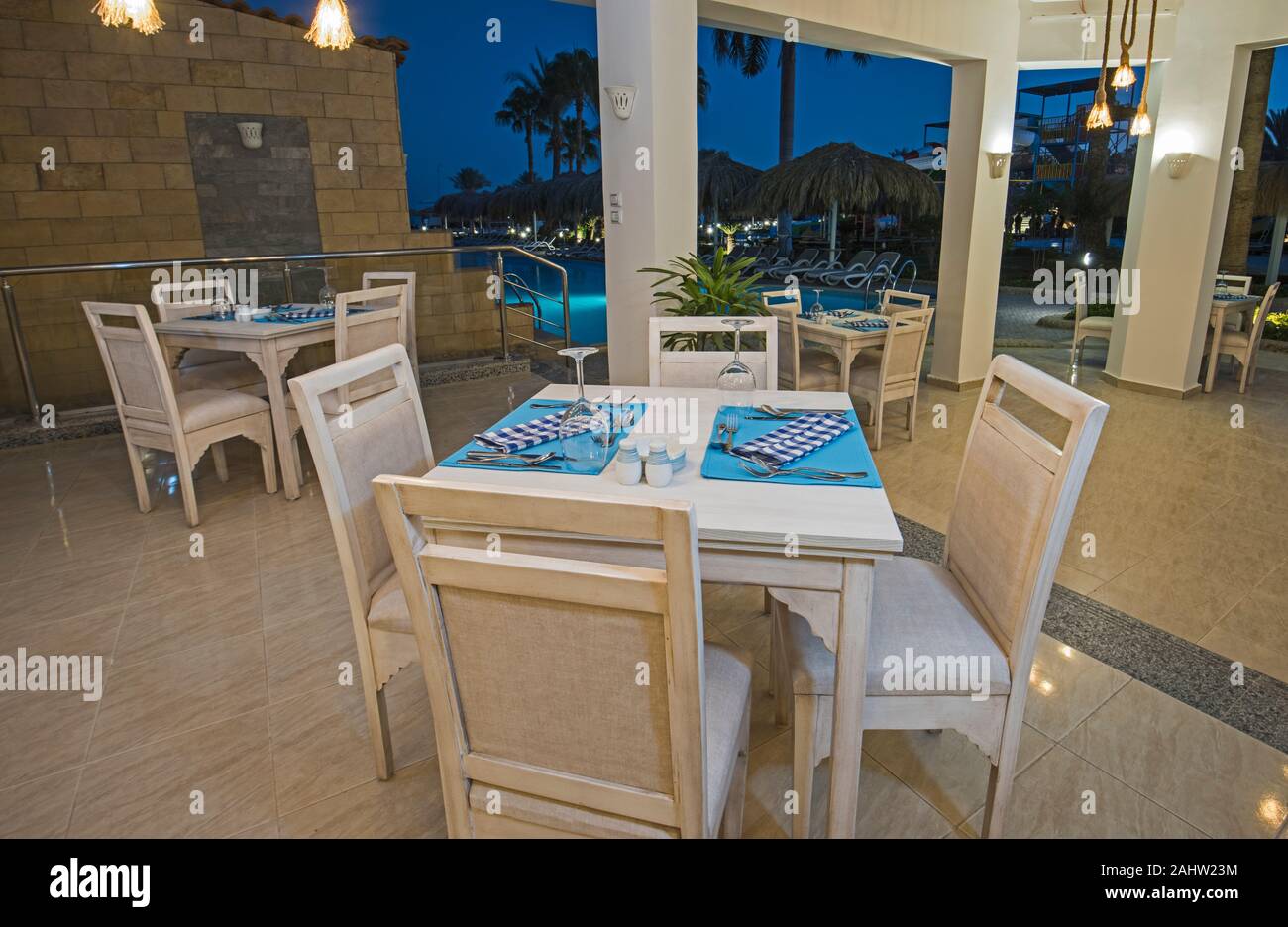 Die Gestaltung des Innenraums ein Luxus hotel restaurant Essbereich mit Einstellung von Swimming Pool bei Nacht Stockfoto