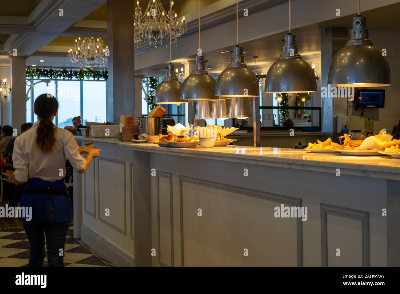 Die Lichter eines heissen Platte oder Essen in einem Restaurant mit einer Kellnerin mit Platten Vergangenheit Stockfoto