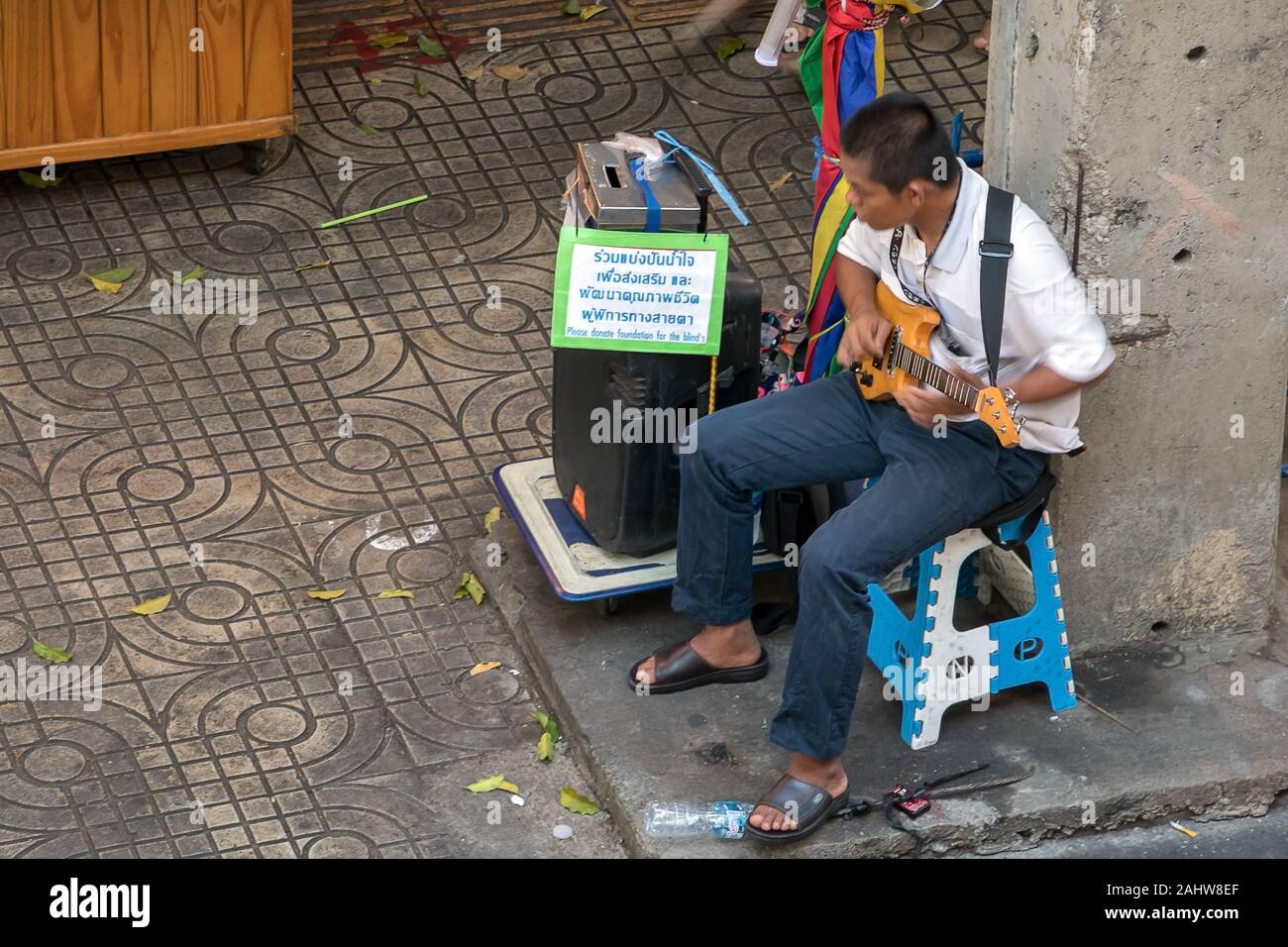 SAMUT PRAKAN, Thailand, 24.Oktober 2019, blinden Sängerin spielt E-Gitarre auf die Straße. Die behinderten Musiker führt auf dem Markt. Stockfoto