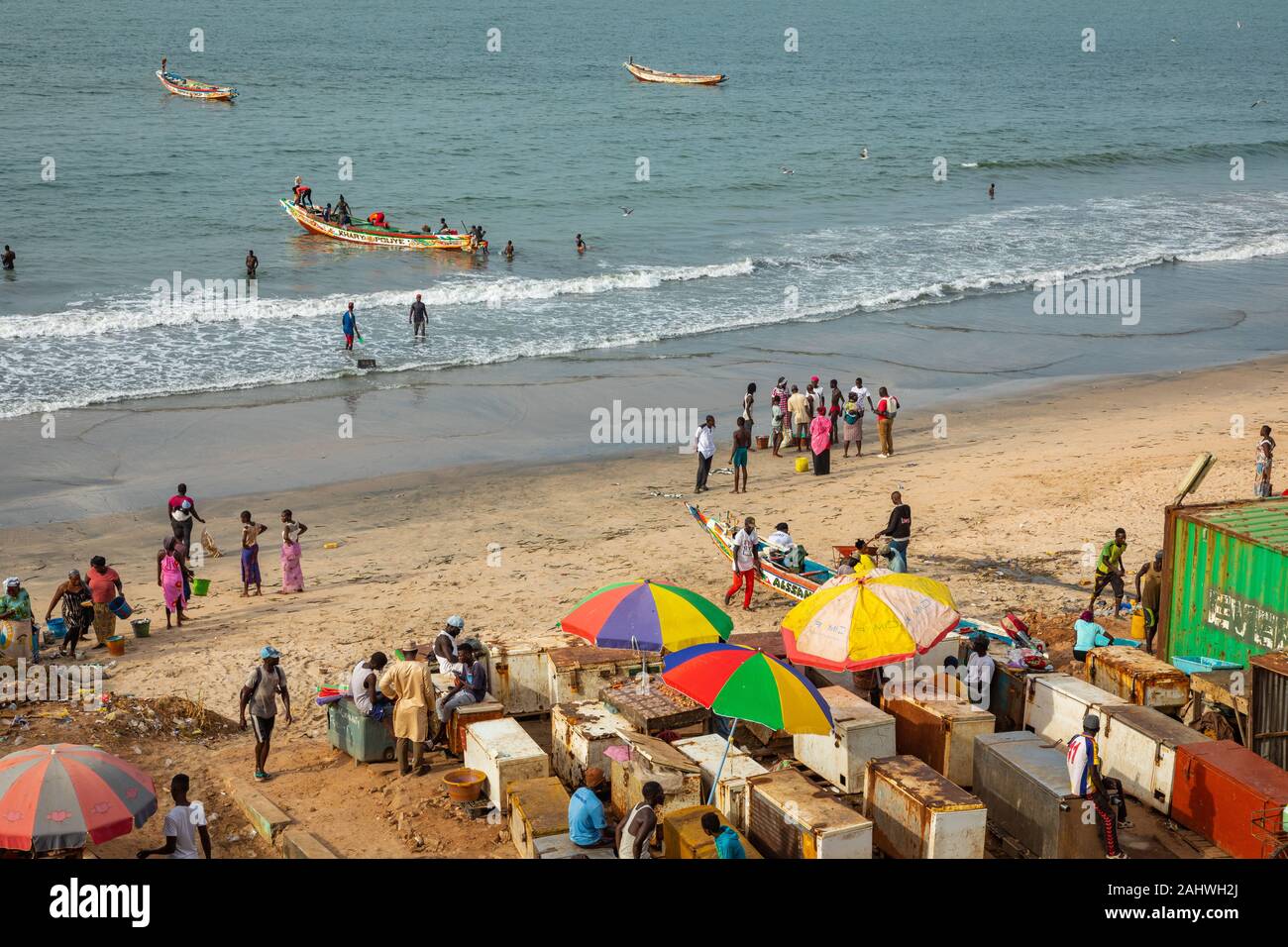 SERREKUNDA GAMBIA - November 21, 2019: Szene mit Männern und Frauen, die Fische aus der Boote am Strand auf Serekunda, Gambia, Westafrika. Stockfoto