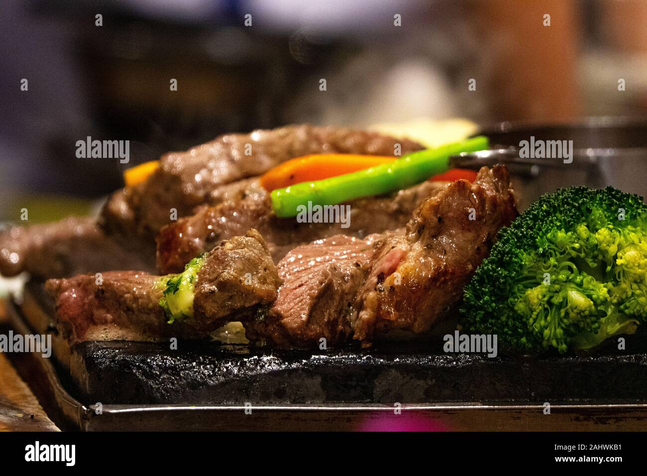 Close up Rindfleisch auf heiße Teller auf Feuer mit Gemüse. Live Cooking im Restaurant. Stockfoto