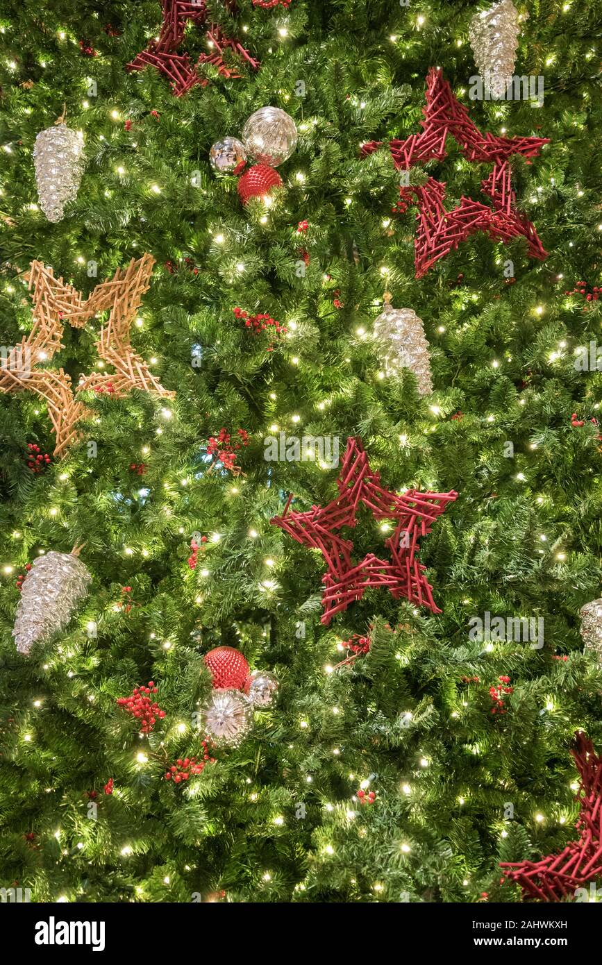 Weihnachtsschmuck hängen an einem grossen Weihnachtsbaum. Stockfoto