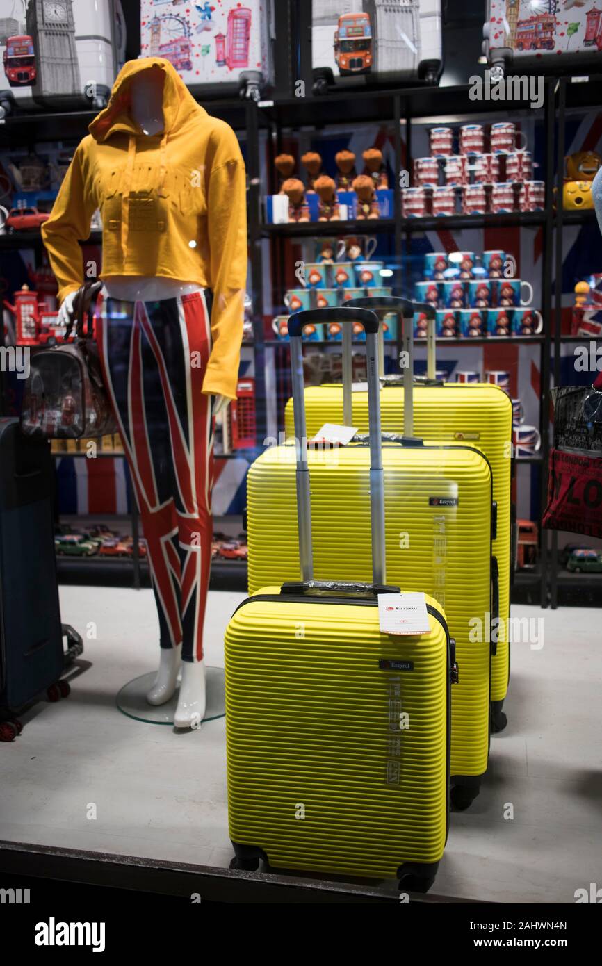 London, Großbritannien - 20 Dezember 2019, Gelb Koffer in verschiedenen Größen, eine Schaufensterpuppe Pullover und Souvenirs in einem Souvenirshop auf der Oxford Street Stockfoto