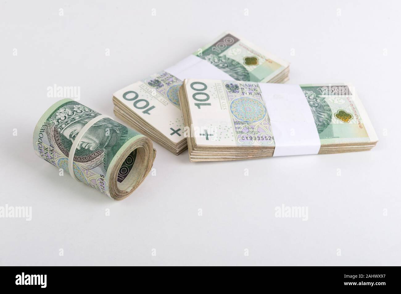 Roll und Stapel des polnischen Zloty auf weißem Hintergrund. Republik Polen Währung Stockfoto