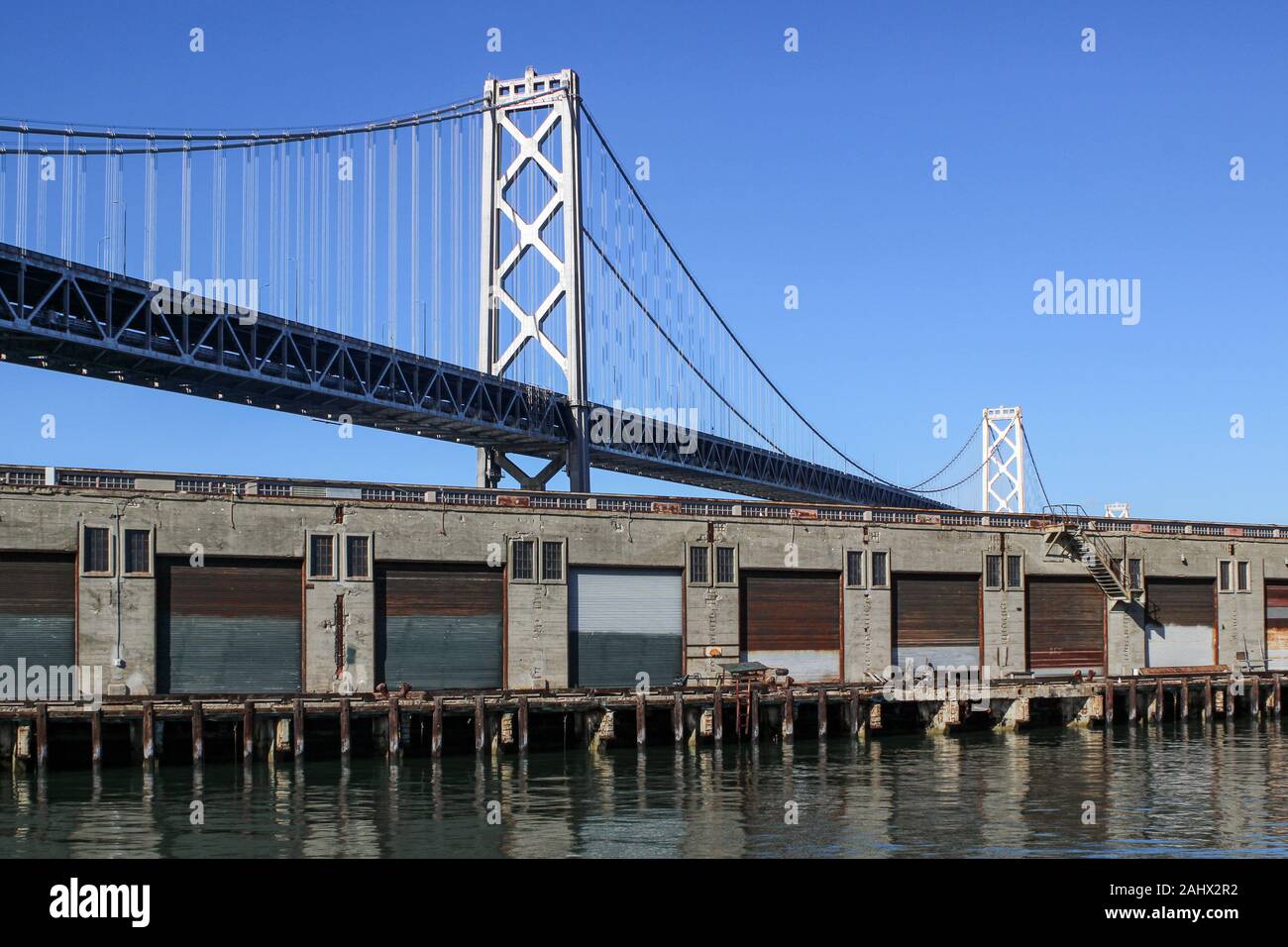 Pier 28 konkrete Lagerhallen und San Francisco-Oakland Bay Bridge in South Beach District von San Francisco, Vereinigte Staaten von Amerika Stockfoto