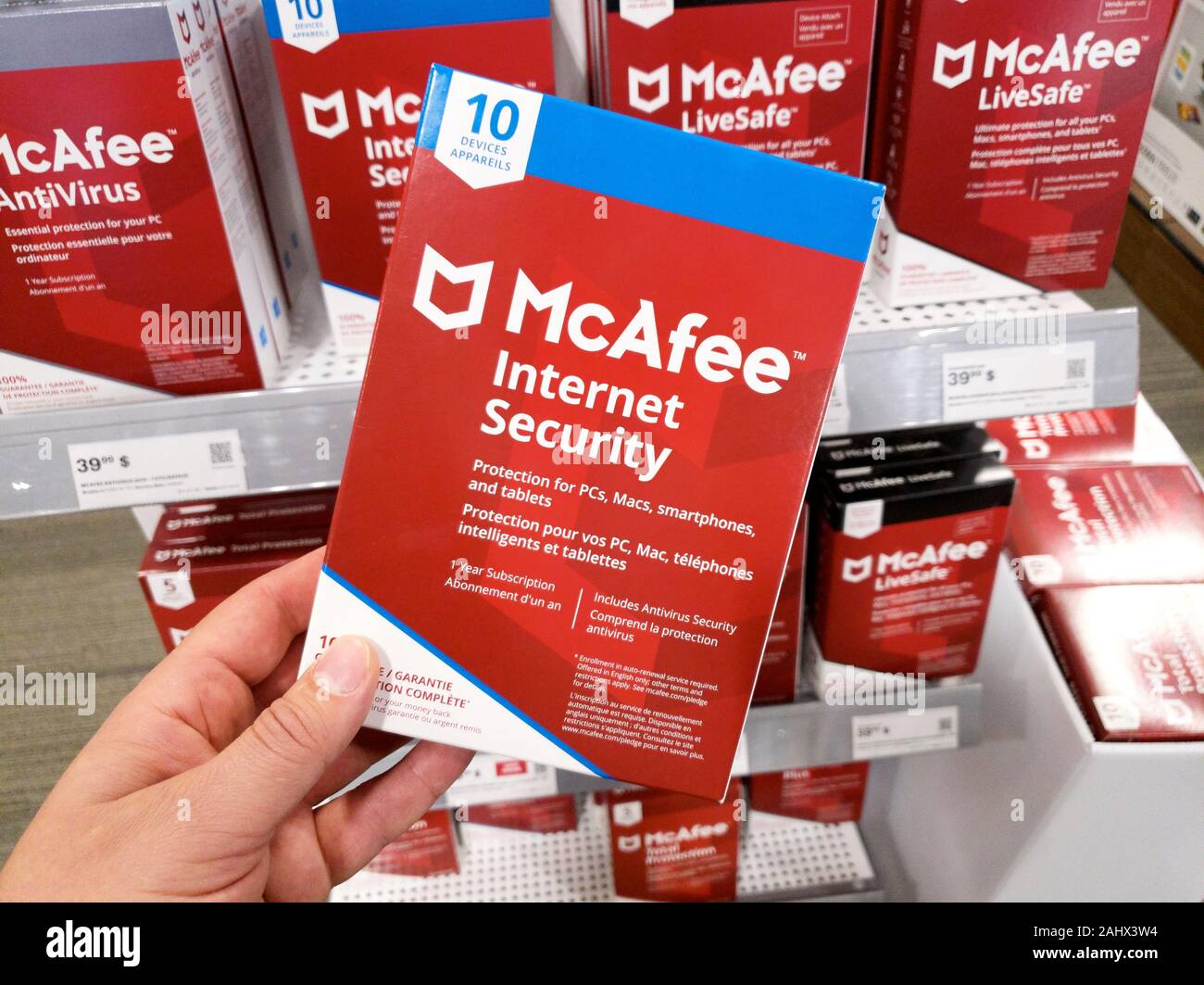 Montreal, Kanada - Dezember 26, 2019: eine Hand, die McAfee Internet Security Box mit Lizenz und Programm. McAfee ist eine US-amerikanische Global computer Secu Stockfoto