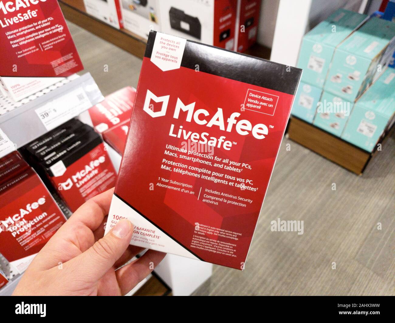 Montreal, Kanada - Dezember 26, 2019: eine Hand, die McAfee Livesafe Box mit Lizenz und Programm. McAfee ist eine US-amerikanische global Computer Security soft Stockfoto