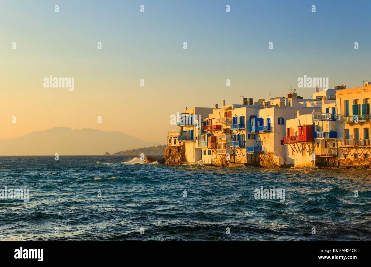 Sonnenuntergang Blick auf die berühmte malerische kleine Venedig auf der Insel Mykonos. Plätschernden Wellen über Bars und Restaurants in der Altstadt von Mykonos, Kykladen, Griechenland. Stockfoto