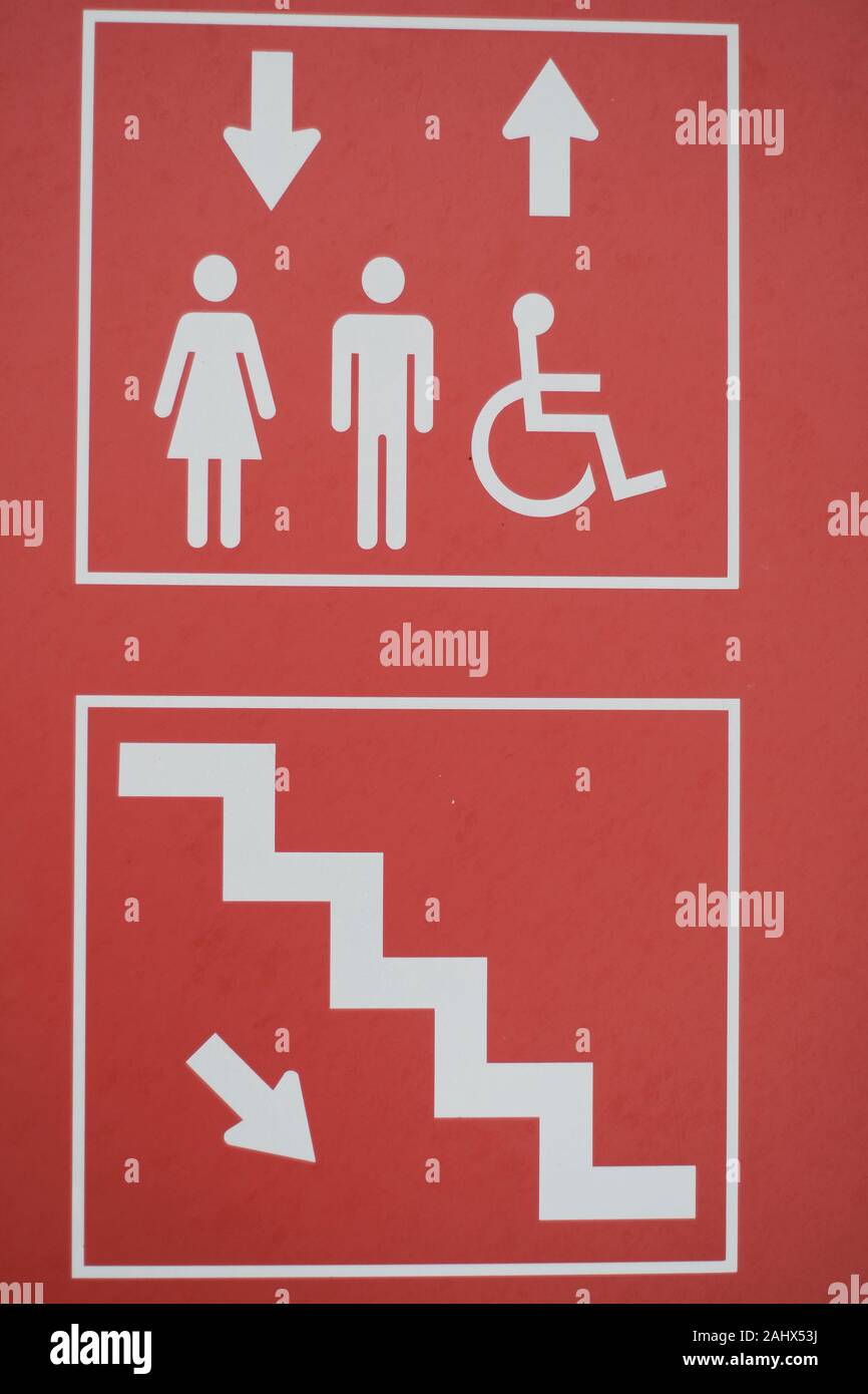 Rotes und weißes Schild in einer örtlichen Garage, das auf Aufzug und Treppenzugang hinweist. Stockfoto