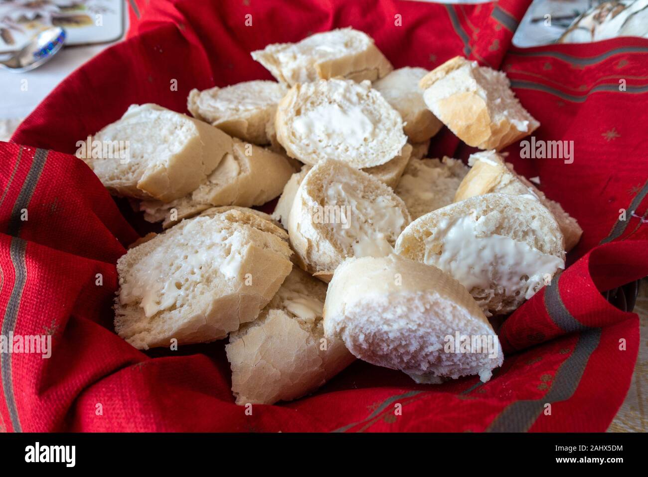 Gebutterte Scheiben baguette Backen auf einem Korb auf einem Tisch. Stockfoto