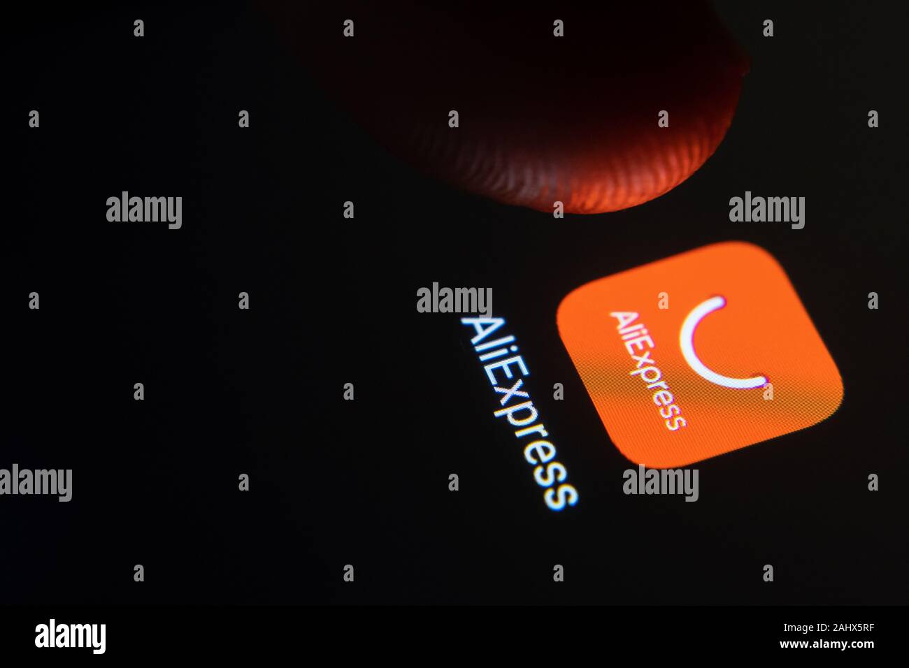 AliExpress App-Symbol auf dem Smartphone-Bildschirm und Finger starten Sie es. Stockfoto