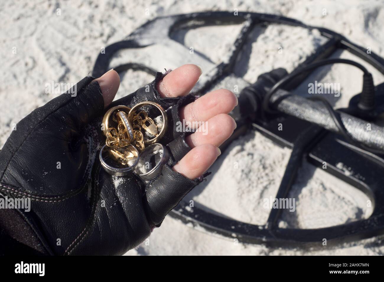 Metall detectorist hält Schmuck von Metalldetektor am Strand in Florida gefunden. Stockfoto