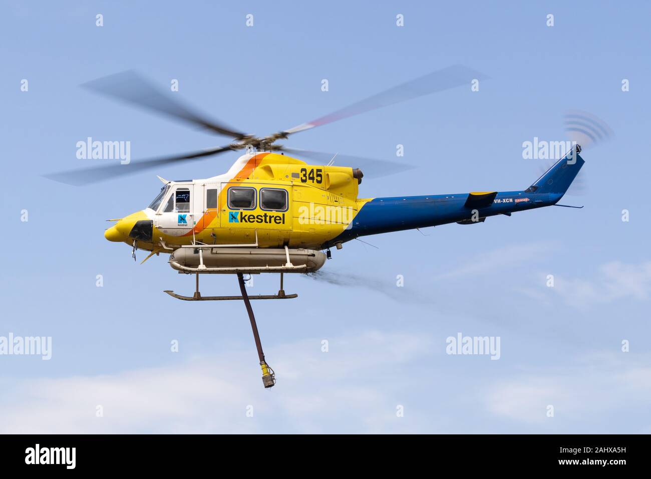 Bell 412 Hubschrauber, die nach dem Befüllen mit einer Belastung von Wasser ein Feuer zu bekämpfen. Stockfoto