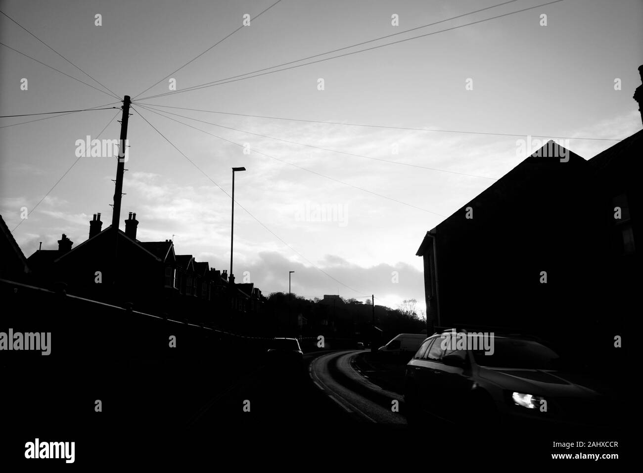 Overhead Telefon und Strom Kabel an einem Gebrauchspfosten, Wohnstraße, Carisbrooke, Isle of Wight, Großbritannien. Stockfoto