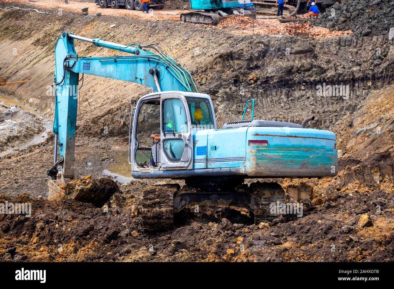 Bagger graben Stiftung an der Baustelle. Bagger arbeiten Nivellierung Boden an der Baustelle. Stockfoto