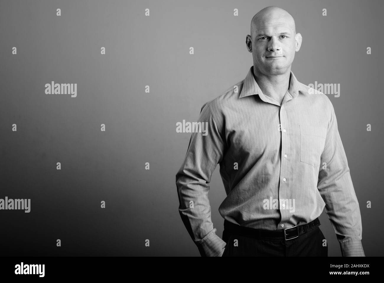Portrait des kahlen Geschäftsmann gegen grauer Hintergrund Stockfoto