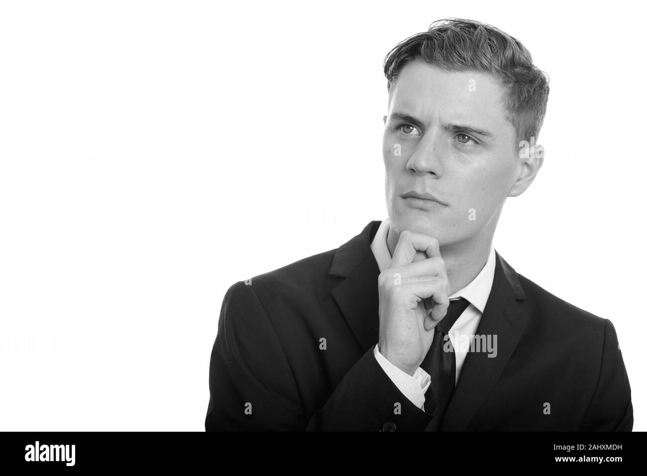 Junge gut aussehender Geschäftsmann mit lockigem Haar zu tragen Anzug Stockfoto