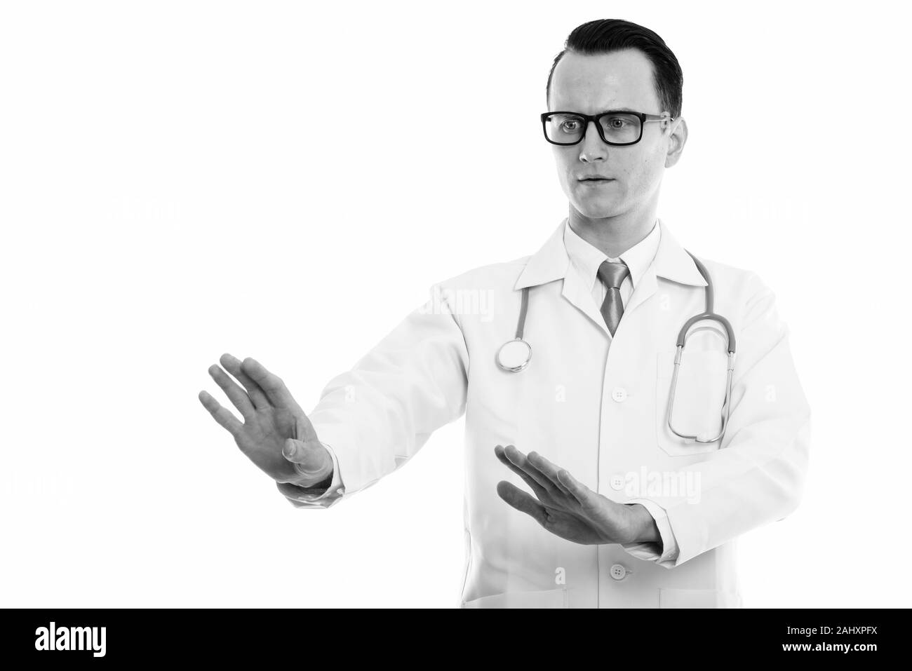 Studio shot Junger stattlicher Mann, in dem der Arzt Ihnen sagte anzuhalten und nach unten schauen. Stockfoto