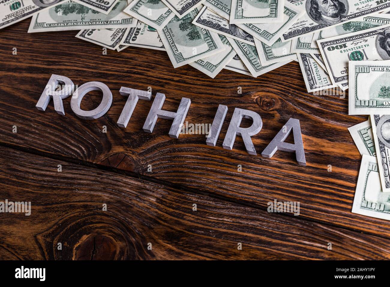 Wörter ROTH IRA auf Holzfläche mit Metallbuchstaben gelegt Und US-Dollar-Banknoten Stockfoto Wörter ROTH IRA auf Holzfläche mit Metallbuchstaben gelegt Und US-Dollar-Banknoten Stockfoto