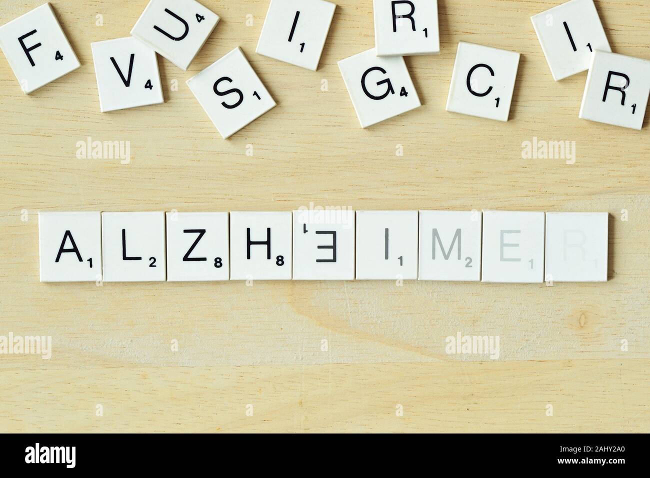 Das Wort Alzheimer mit SCRABBLE-Spiel Buchstaben - Begriff des verblassenden Erinnerungen geschrieben Stockfoto