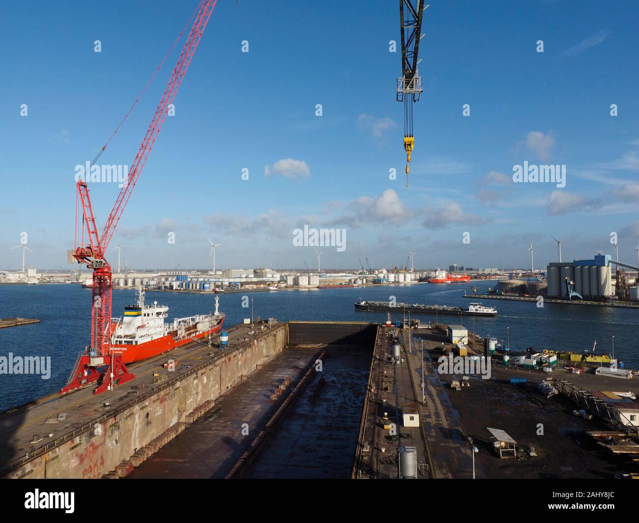 Der Antwerpener Hafen von einem hohen Kran gesehen, mit Dry Dock im Vordergrund, verschiedene Schiffe, und blauer Himmel. Antwerpen, Belgien Stockfoto