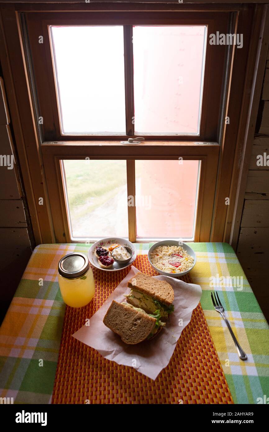 Picknick an der Ferryland Leuchtturm in Neufundland und Labrador, Kanada. Das Mittagessen mit einem Sandwich, Getränk, Salat, Teegebäck und Clotted cre Stockfoto