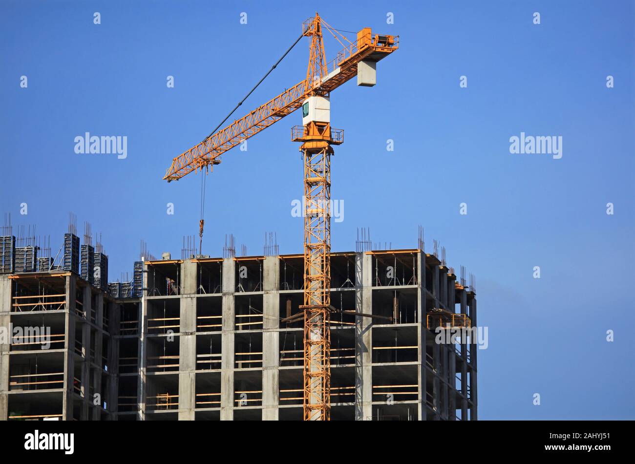 Ein Baukran auf der Baustelle von monolithischen Apartment Gebäude. Gebäude Baustelle mit Kran. Baustelle Stockfoto