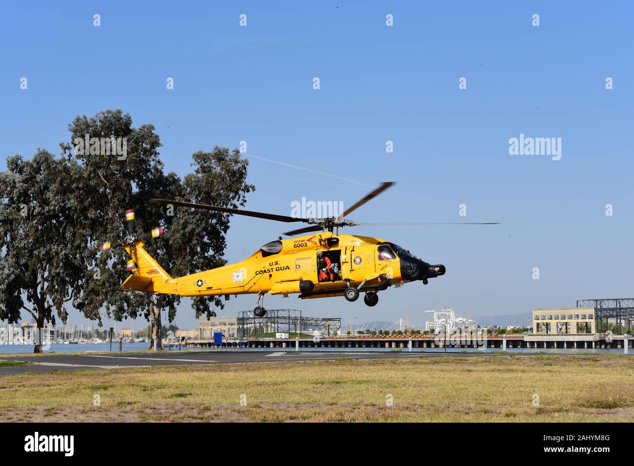 Ein fliegendes Personal an Bord eines MH-60 Jayhawk Helikopter von Air Station Astoria fährt Coast Guard Island in Alameda, Kalifornien, nach Abheben servicemembers vom San Diego - Maritime Security Response Team West auf der Grundlage der Sicherheit wurden während des San Francisco Fleet Week. Die Mannschaft wurde festgelegt, eine schnelle Seil Demonstration aus dem Jayhawk auf die Coast Guard Cutter standhaft während der Flotte Woche Parade der Segel zu leiten. U.S. Coast Guard Foto von Petty Officer Matthew S. Masaschi Stockfoto