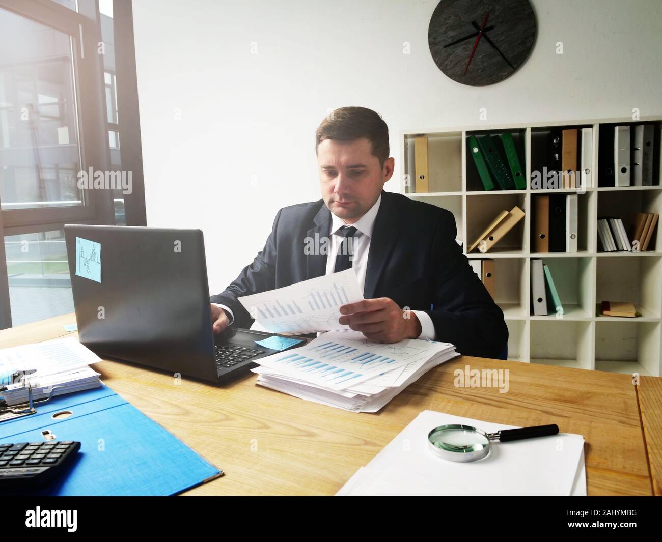 Ein Geschäftsmann arbeitet an den Arbeitsplatz. Büro mit Papieren und Berichten. Stockfoto