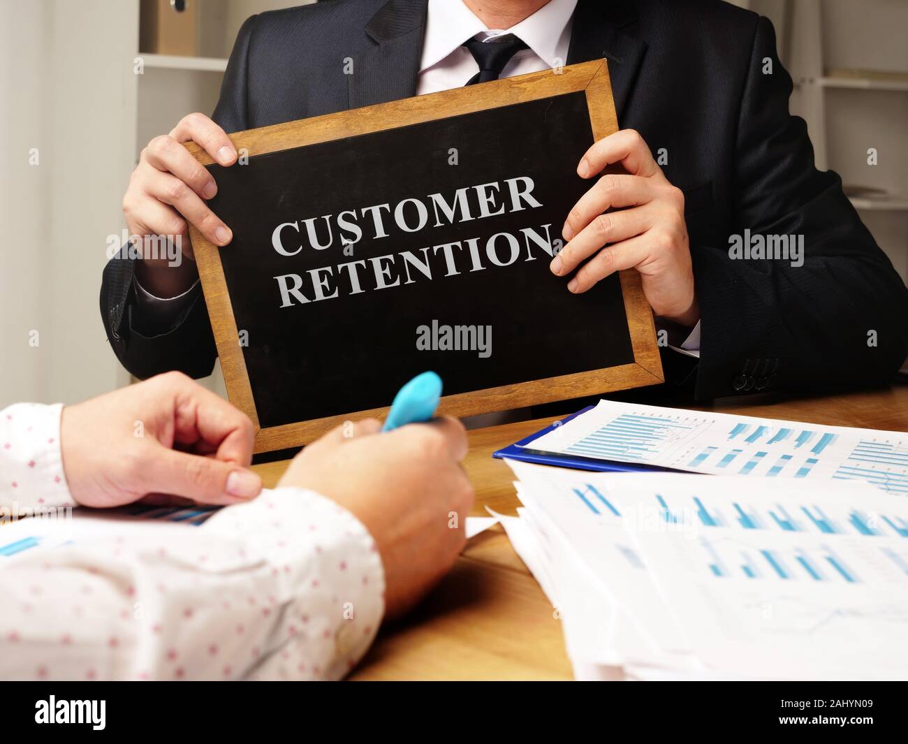 Manager hält die Kundenbindung Zeichen an die Tafel. Stockfoto