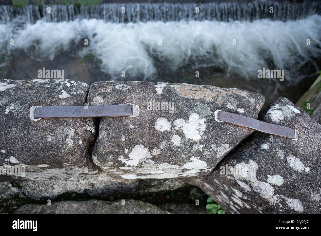 Metallklammern Holding die alte Dimension Steinblöcke einer römischen Brücke. Metallische Schelle oder Heften, die mit führen zu den Stein Material verbindet Stockfoto
