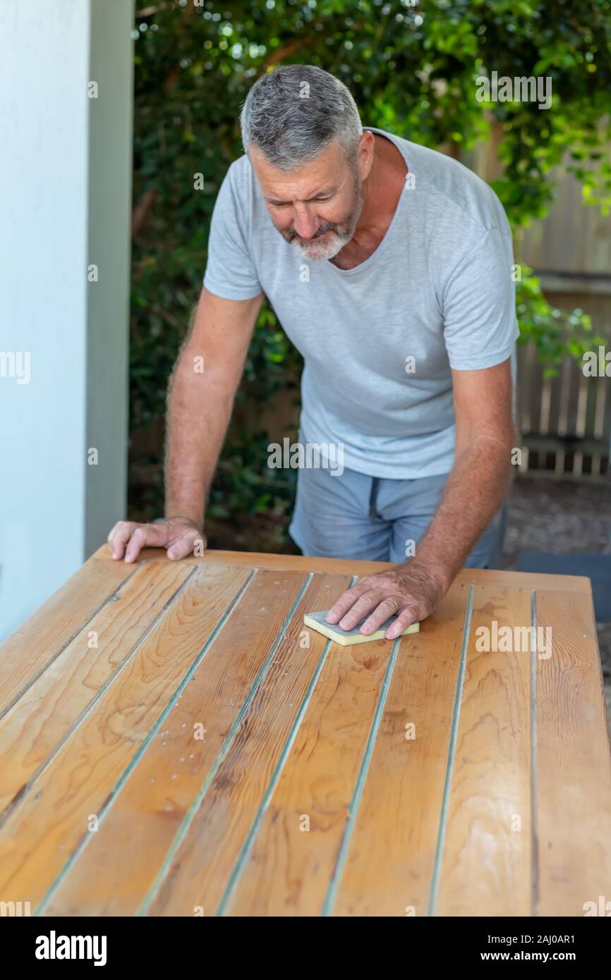 Ein Mann der Arbeit an Recycling Holz Tisch im Garten, Tischler arbeiten. Stockfoto