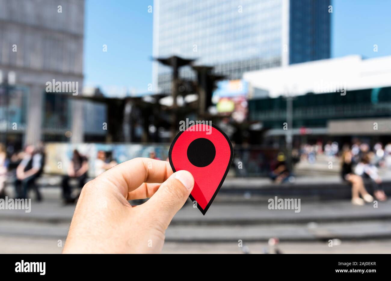 Nahaufnahme der Hand eines jungen kaukasischen Mann mit einem roten Marker an der beliebten Alexanderplatz in Berlin, Deutschland Stockfoto