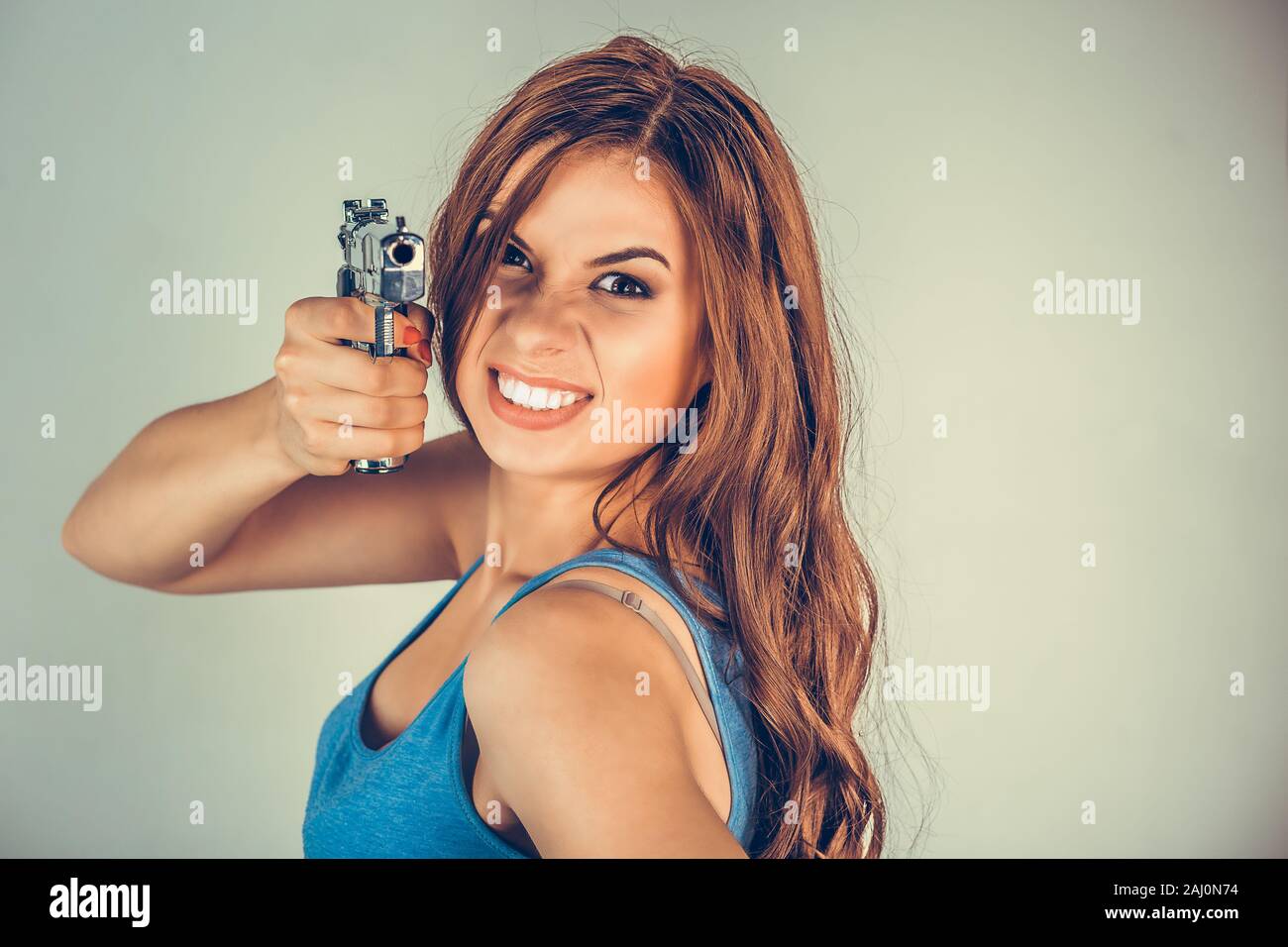 Schöne junge Frau mit einer Pistole. Brunette holding Pistole suchen,, die Kamera zeigt. gewalttätigen Rebellen Gangster bandit Selbst- Justiz Konzept. Mixe Stockfoto