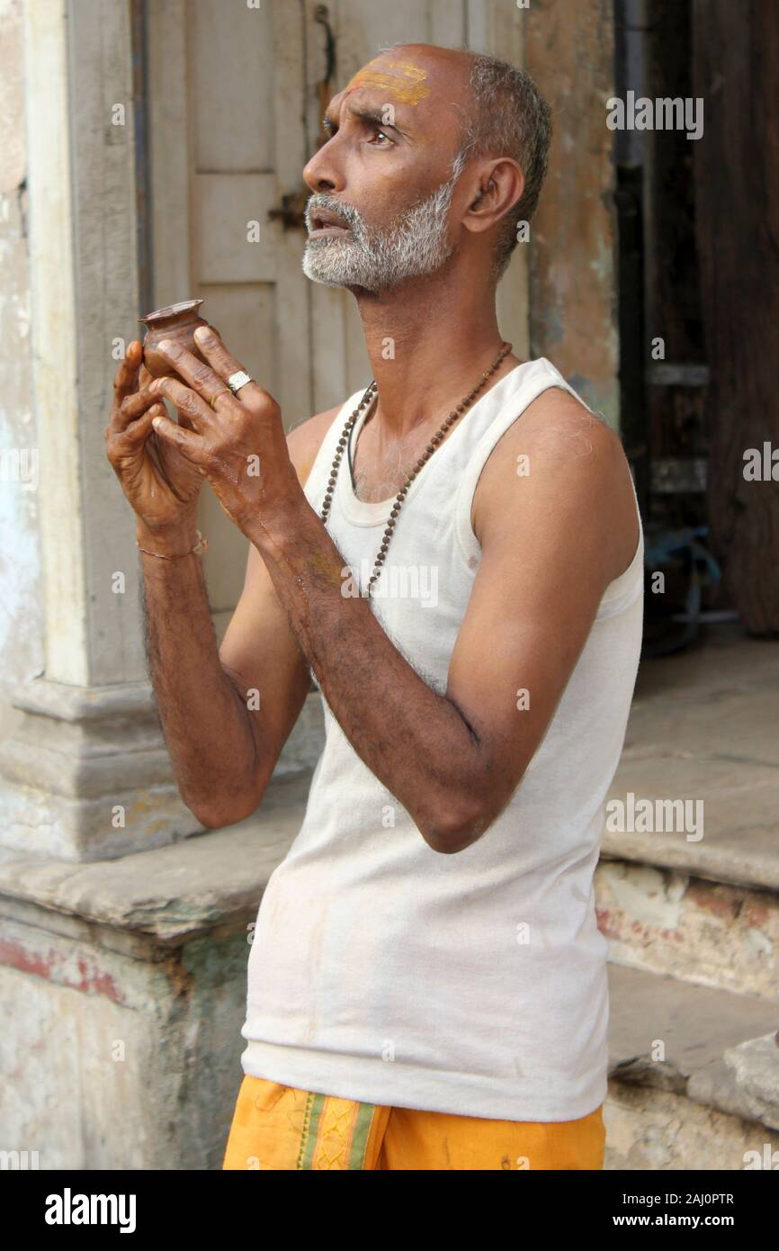 Mann eine Puja außerhalb seines Hauses, Alte Ahmedabad, Gujarat, Indien. Stockfoto