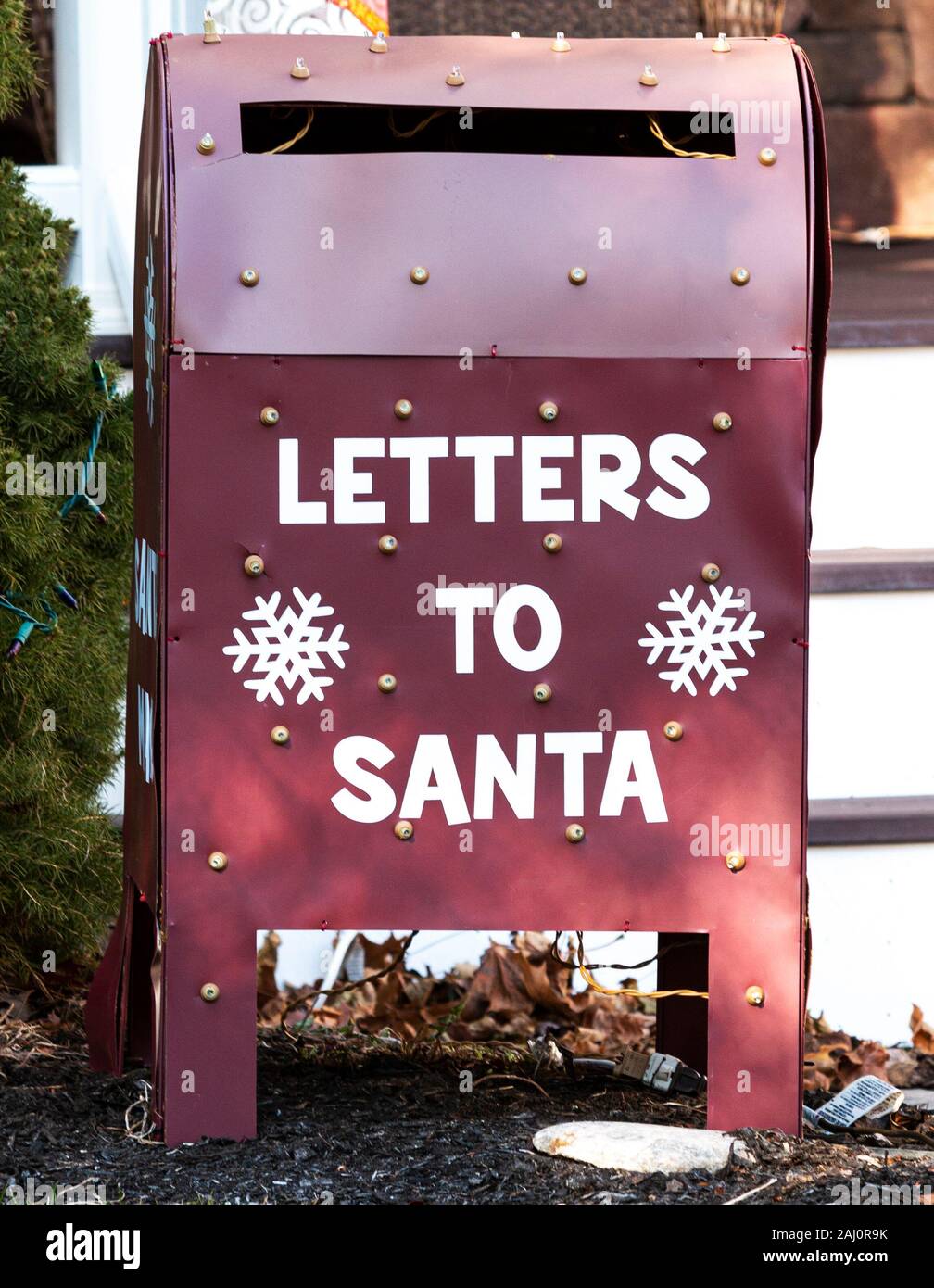 Nahaufnahme eines Urlaub Dekoration, dass es einen roten Briefkasten mit Buchstaben zu Santa geschrieben auf der Vorder- und Weihnachtsbeleuchtung. Stockfoto