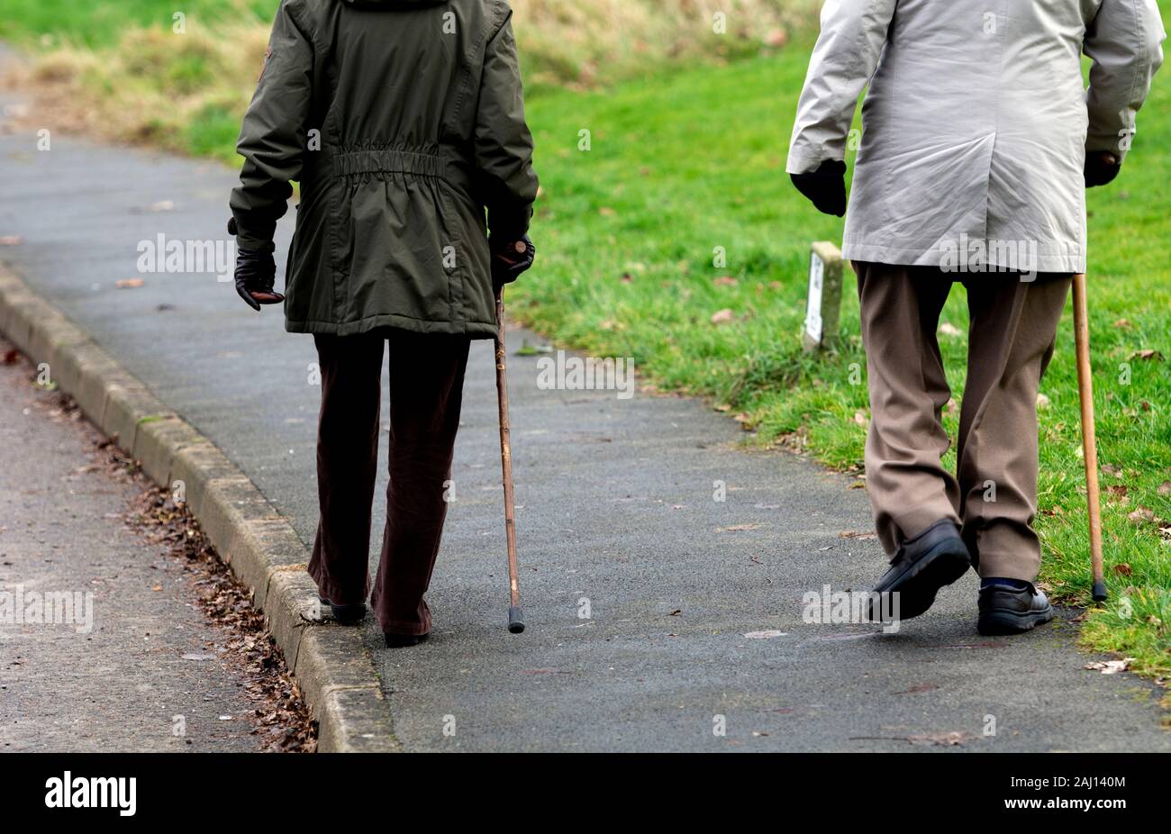 Älteres Paar im Winter mit Stöcken, Großbritannien Stockfoto