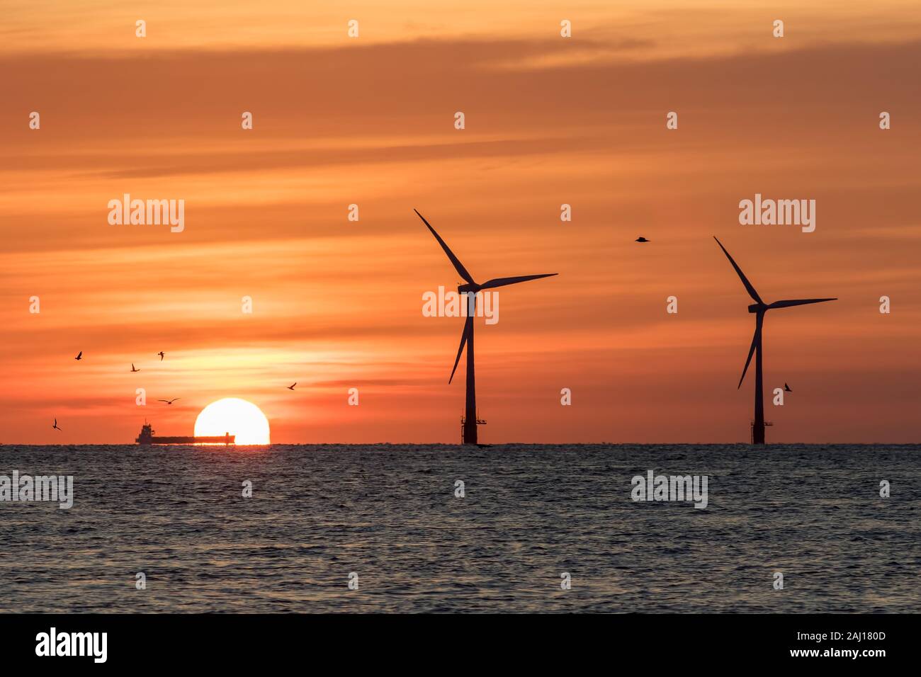 Solarenergie und Windenergie. Klimawandel und globale Erwärmung. Offshore-windfarm Turbinen von der aufgehenden Sonne Silhouette mit der Industrie in Form von Stockfoto