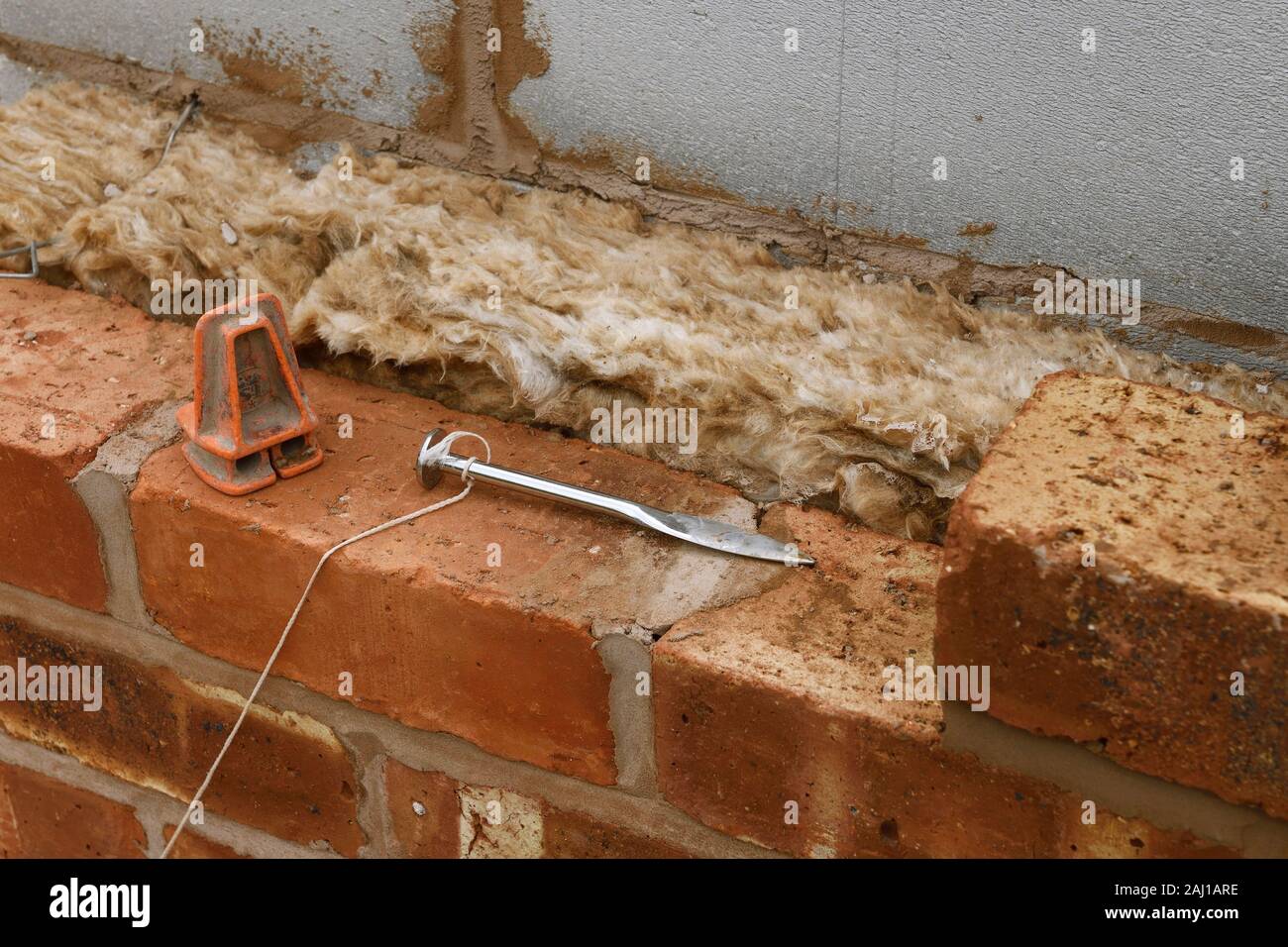 Nahaufnahme Detail einer zweischaligen Wand mit einem UK Baustelle zeigt die mineralische Wand Isolierung und einem Brick Line Stockfoto